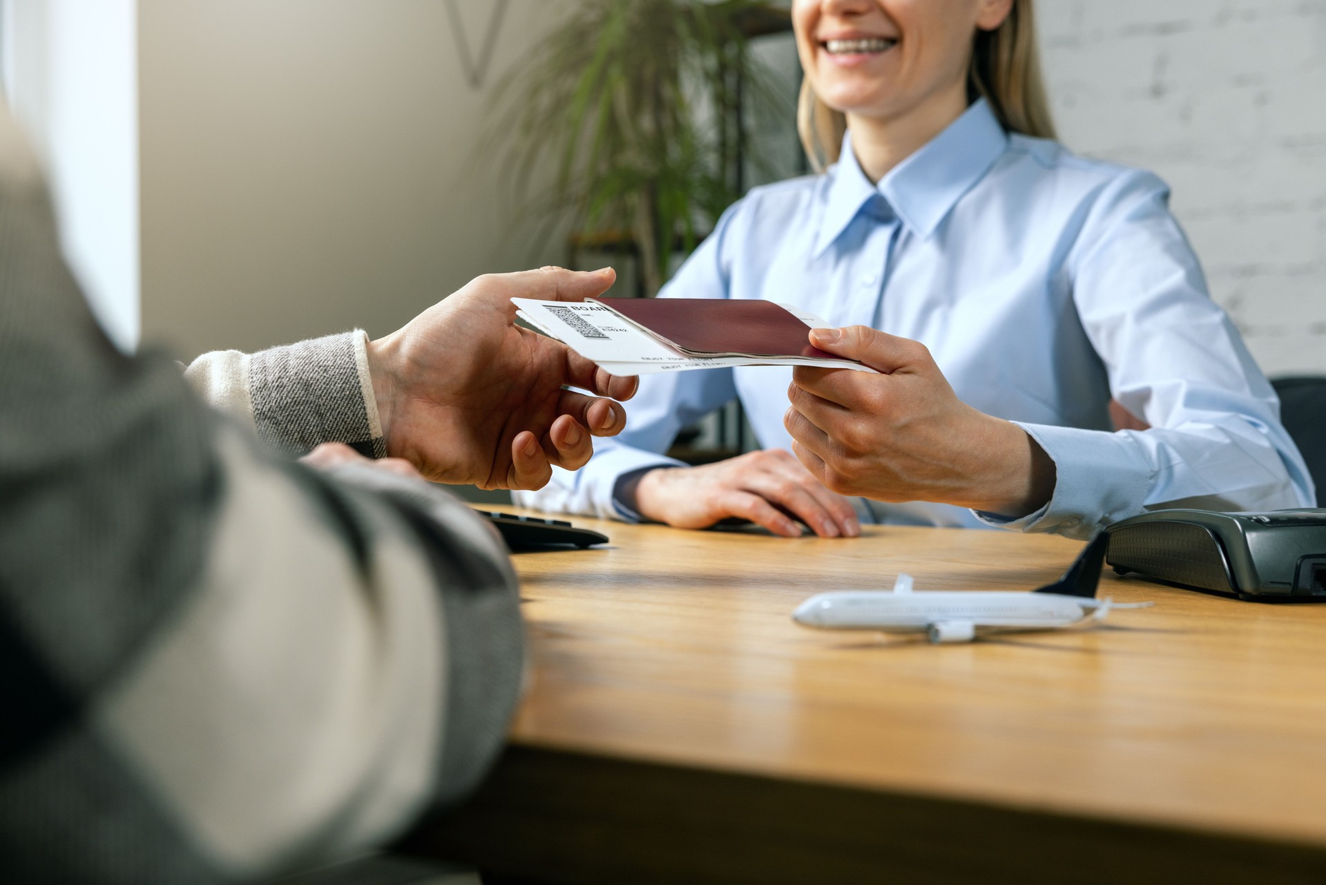 travel agent give flight tickets and passport to customer at agency office. vacation planning service